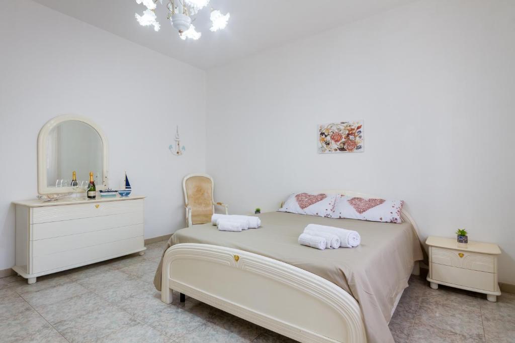 una camera bianca con letto e specchio di Air-conditioned Villa 300 Meters From Porto Cesareo Beach With Parking a Porto Cesareo