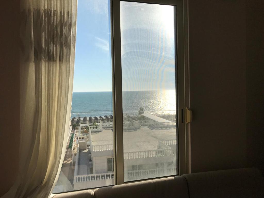 a window with a view of the ocean from a hotel room at Sea View Apartment Shkëmbi i Kavajes in Durrës