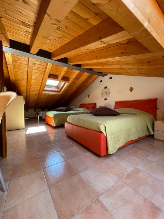 - 2 lits dans une chambre dotée de plafonds en bois dans l'établissement Casa RoGi Bardolino Lake, à Bardolino