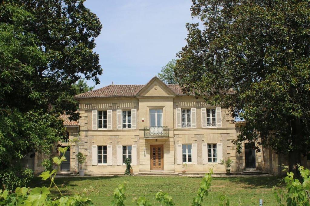 una casa grande con árboles delante de ella en Malis Castera en Saint-Jean-de-Blaignac