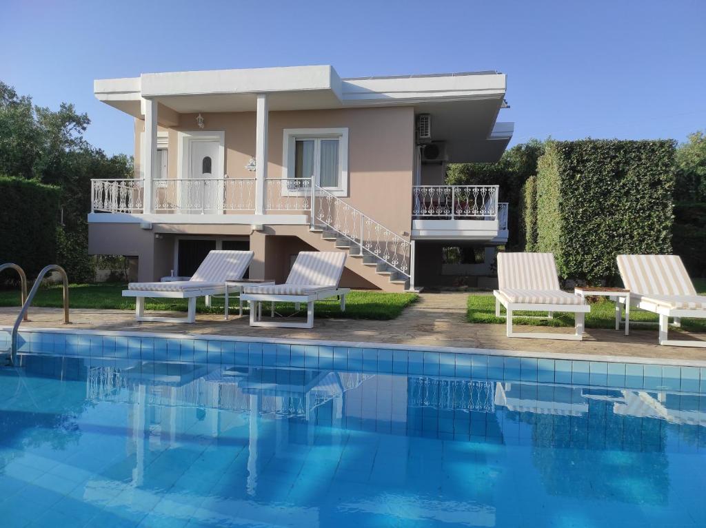 a villa with a swimming pool and a house at Villa Aphrodite in Rizá