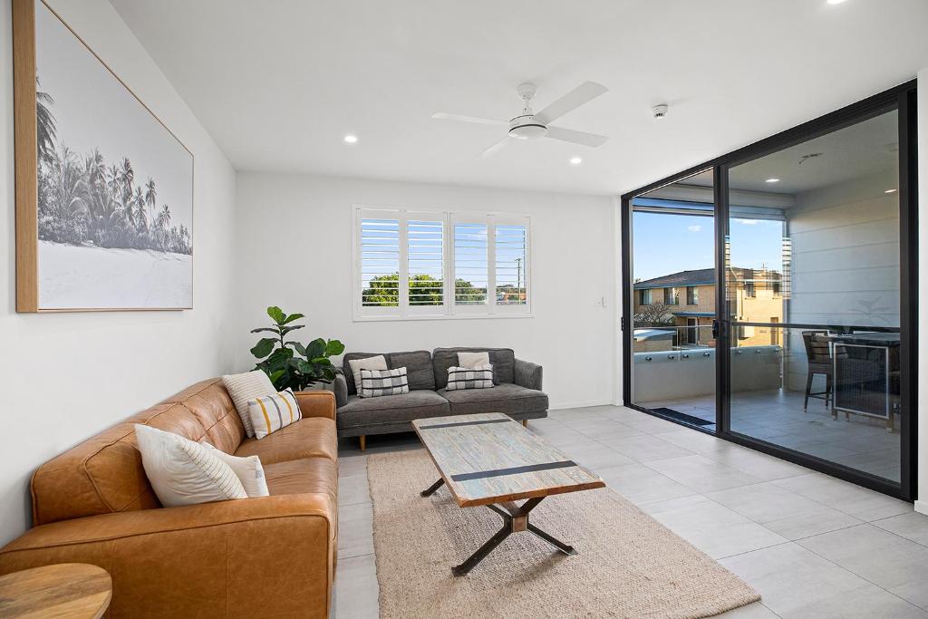 a living room with a couch and a table at Rockpool 2 Sawtell Beach - Just steps to Restaurants and 2 min Stroll to Beach! in Sawtell