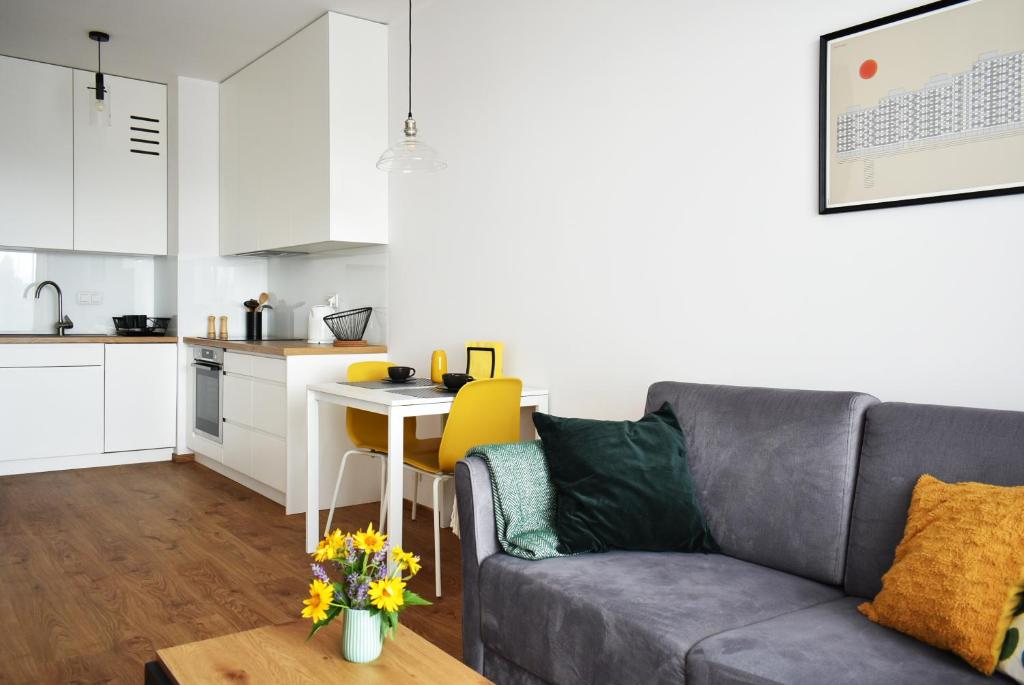 a living room with a couch and a table in a kitchen at Fabryczna Apartment in Łódź