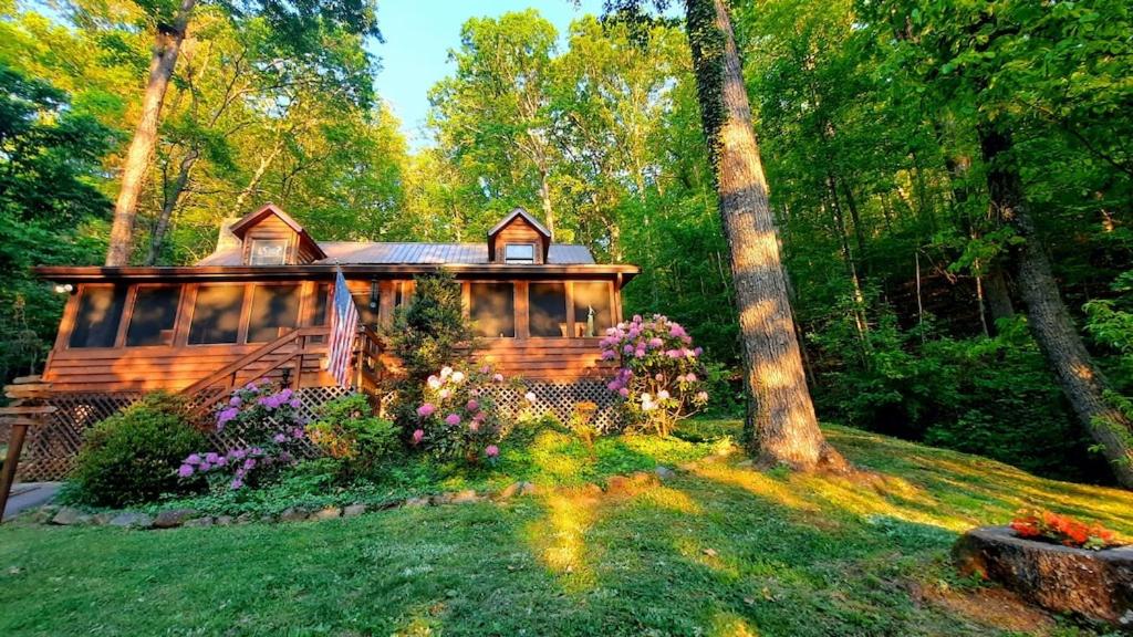 a log cabin in the woods with a garden at The Mountain Forager Cabin, Whitewater Rafting, Polar Express, Hot Tub, Home Gym, SMNP, SM Railroad in Bryson City