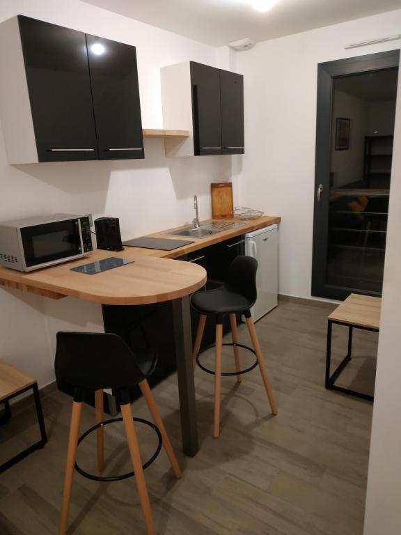 cocina con mesa, sillas y microondas en Pleinitude en Trangé