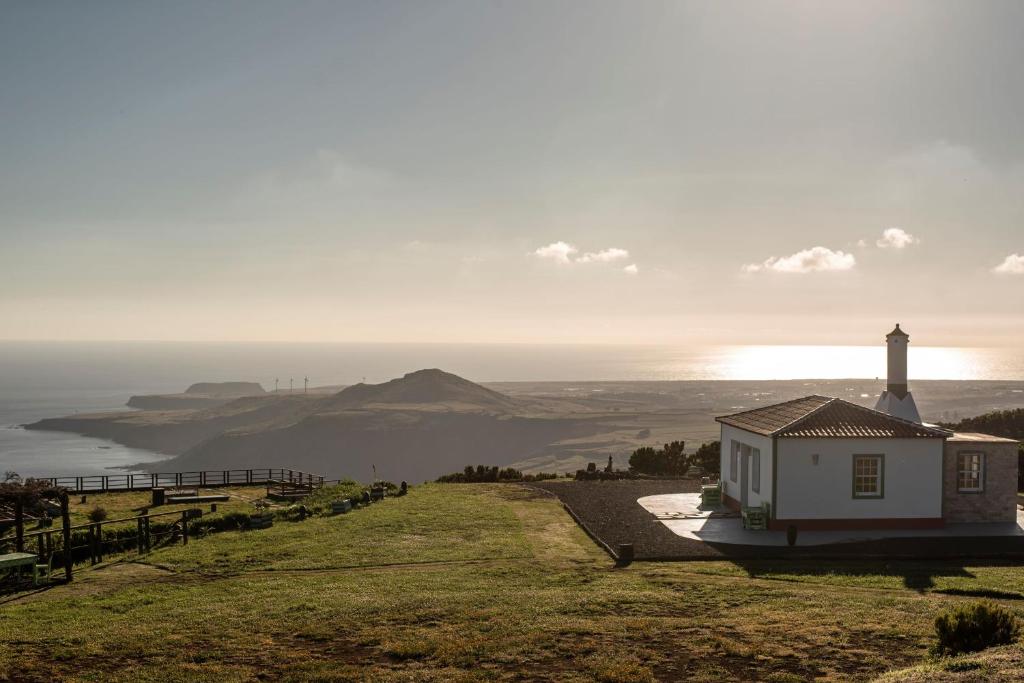 a lighthouse on a hill with a view of the ocean at Casita - Cantinho do Paraíso in Vila do Porto