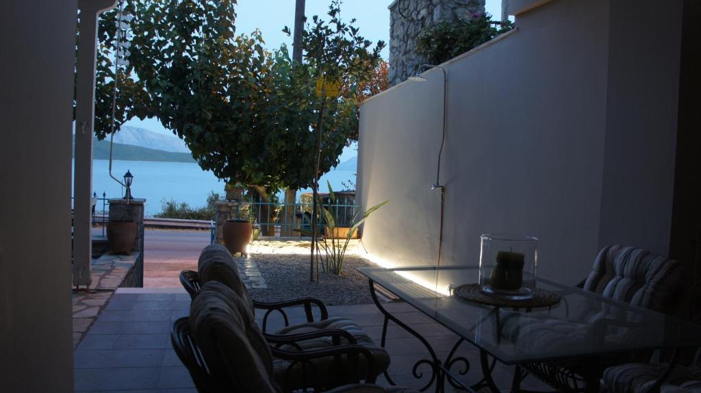 un patio con mesa y sillas con vistas al agua en EOΣ en Nikiana