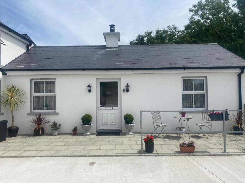 a white house with a patio in front of it at Hillview Cottage in Bantry