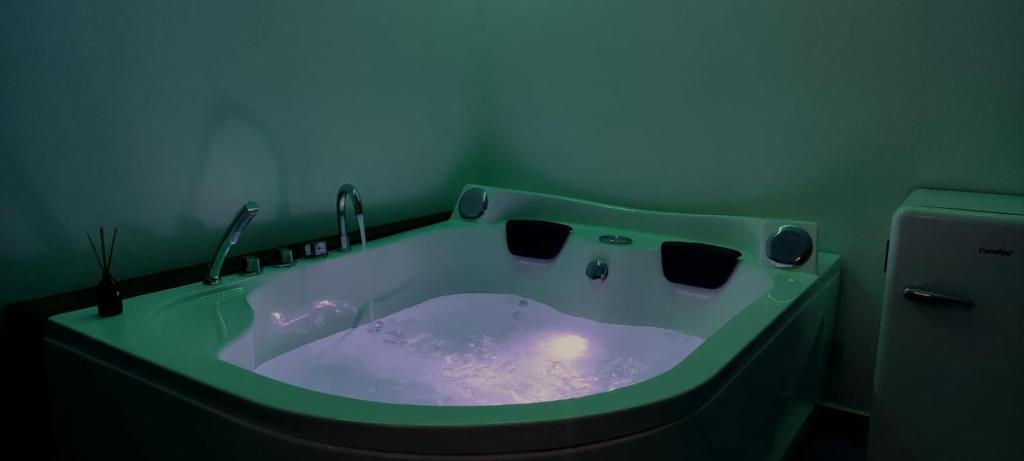 a bathroom with a green tub with a candle in it at Beb il Vicoletto in Maratea