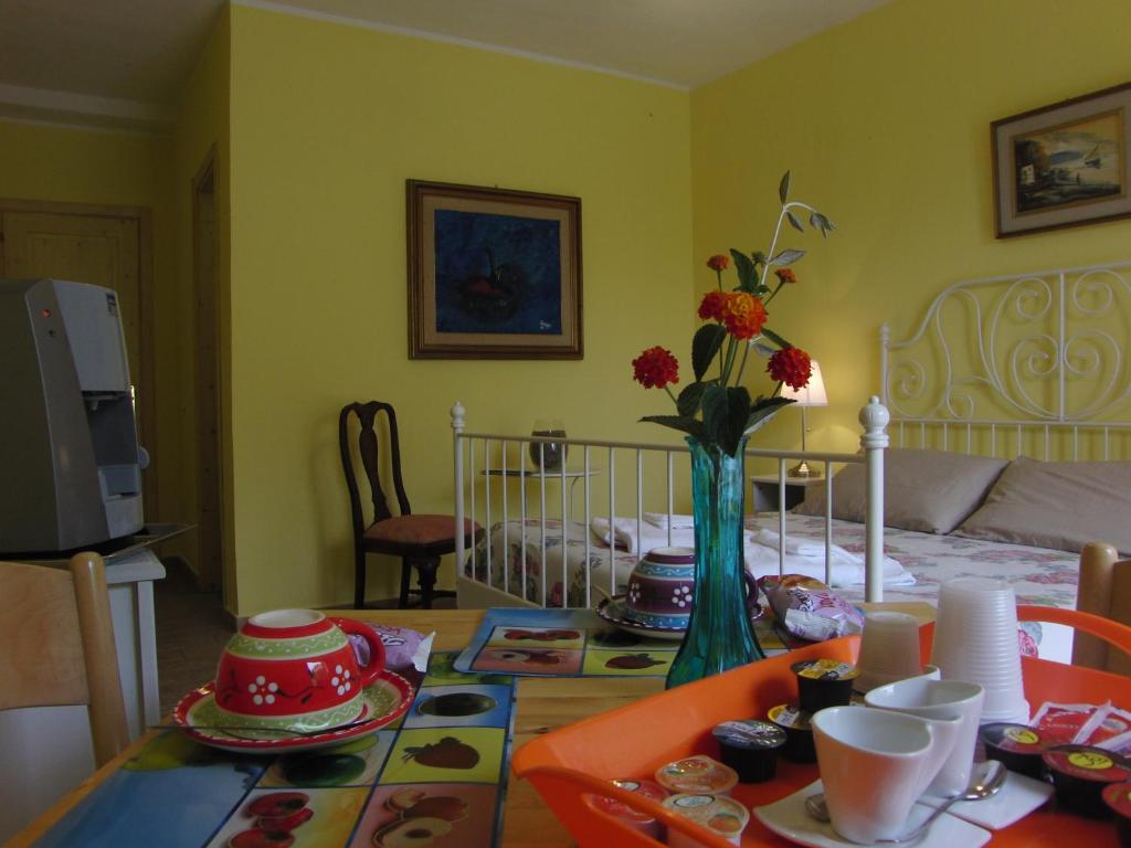 a dining room table with a vase of flowers on it at Locanda Degli Etruschi in Montalto di Castro