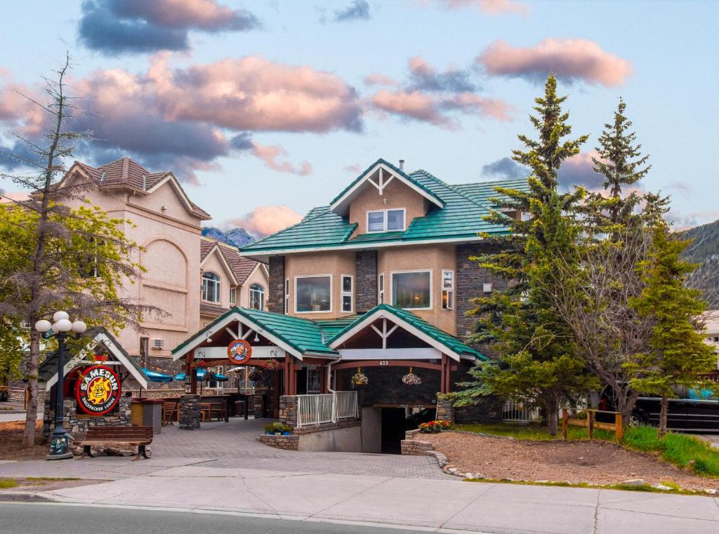 a large building with a green roof on a street at Samesun Banff Hostel in Banff