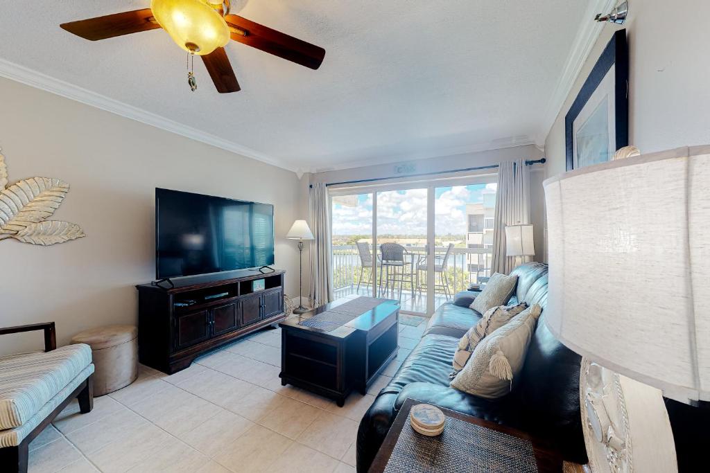 a living room with a couch and a flat screen tv at Water View 402 in Clearwater Beach