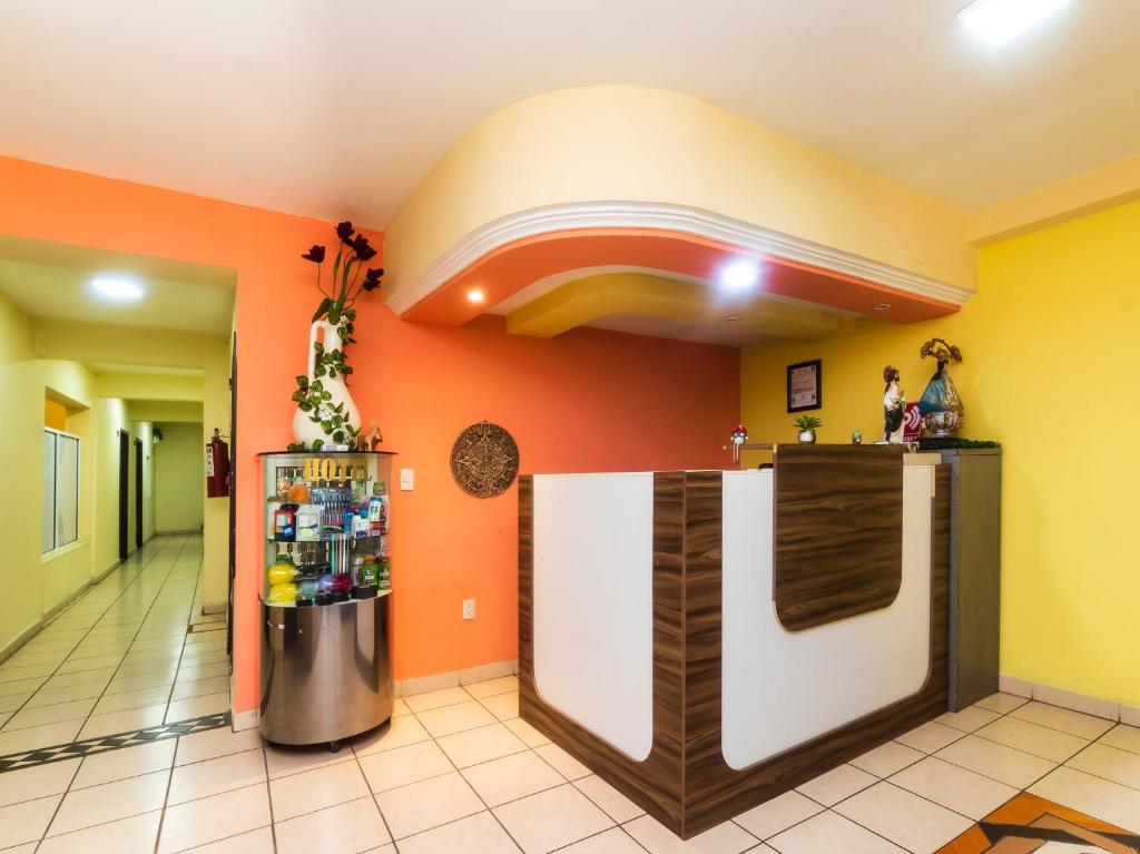 uma cozinha com paredes cor de laranja e um frigorífico em Hotel Zaragoza em San Juan de los Lagos