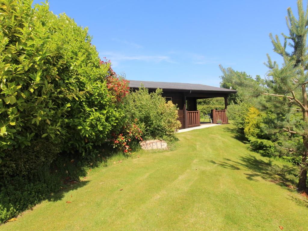 a garden with a house in the background at Maple Lodge in Bodmin