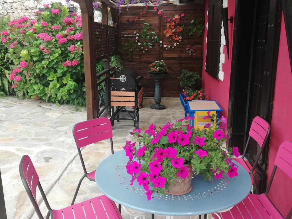 a table with pink chairs and flowers on a patio at Vibrant holiday home in Villanueva with terrace in Villanueva