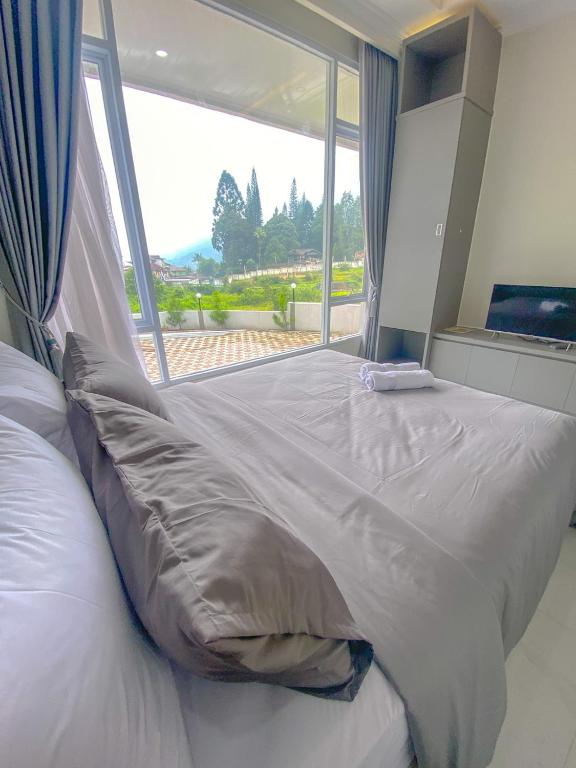 Postel nebo postele na pokoji v ubytování Algara Puncak Hotel