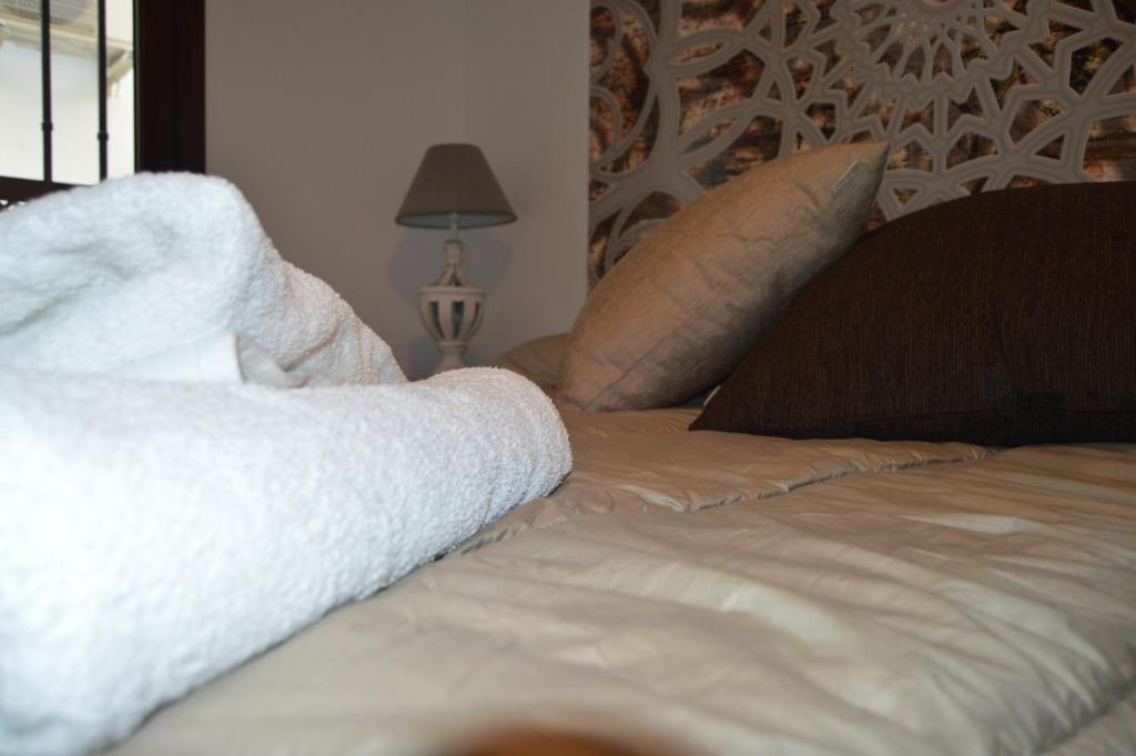 A bed or beds in a room at ALCAZAR VIEJO SUITE Tourist Córdoba