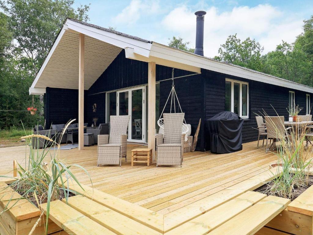 une terrasse en bois avec des chaises et une maison dans l'établissement Holiday home Læsø LIII, à Læsø
