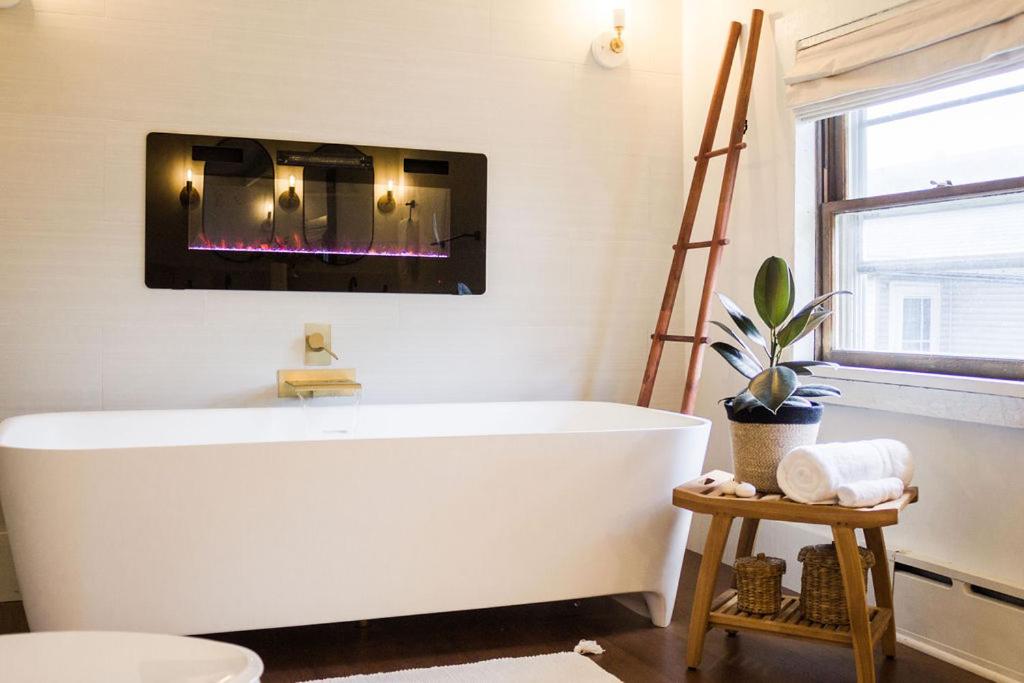 a white bath tub in a bathroom with a fire place at The Loft at Woodhaven Hideaway in Myerstown