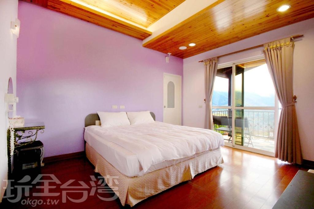 a bedroom with a bed with purple walls and a balcony at Luxembourg in Ren&#39;ai