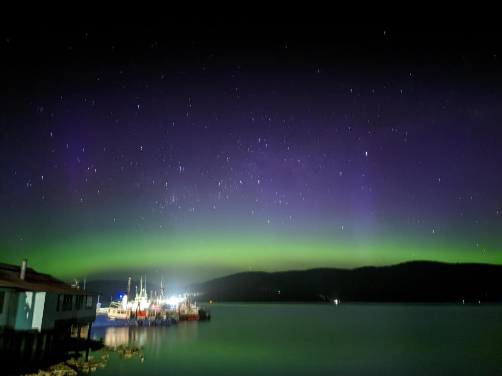 a group of boats in the water under the green northern lights at Smugglers Rest Apartments Dover in Dover