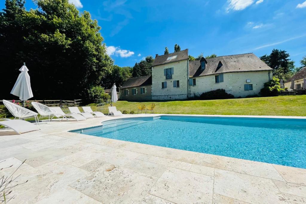 a swimming pool with chairs and a house in the background at Seigneurie Les Aulnaies exceptional building with swimming pool in Fondettes