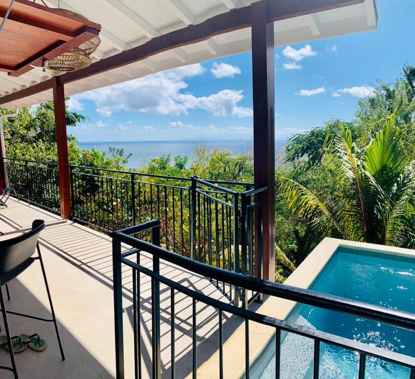 a balcony with a pool and a view of the ocean at Magnifique Villa Bauhinia, Piscine vue mer in Sainte-Luce