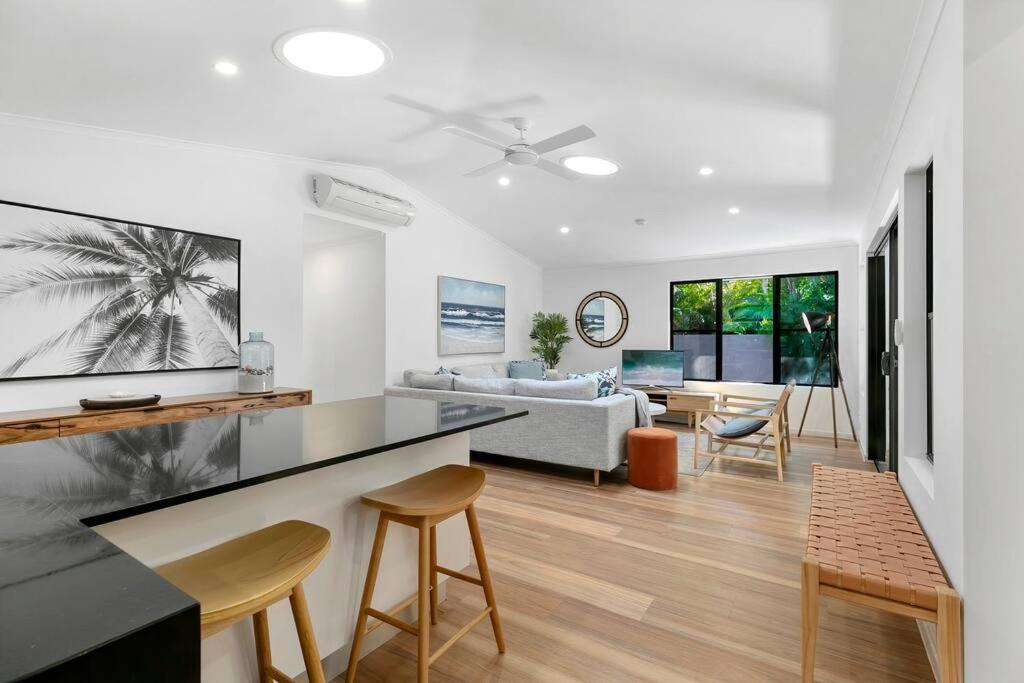 a kitchen and living room with a table and chairs at Central Tropical Oasis with Pool in Noosaville