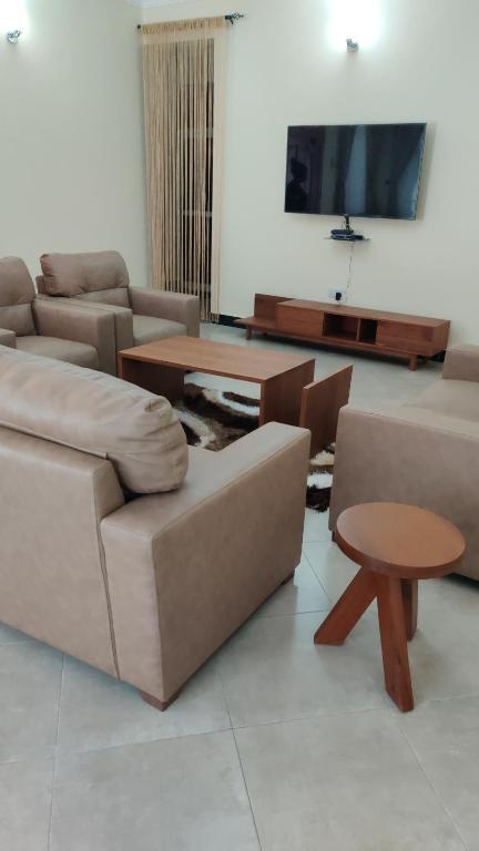 ein Wohnzimmer mit einem Sofa und einem Tisch in der Unterkunft FAD Home & Apartments in Dodoma