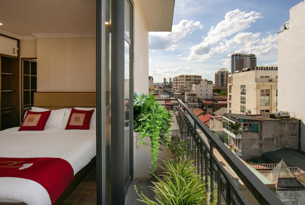 a bed on a balcony with a view of a city at Au Coeur d'Hanoi Apartment in Hanoi