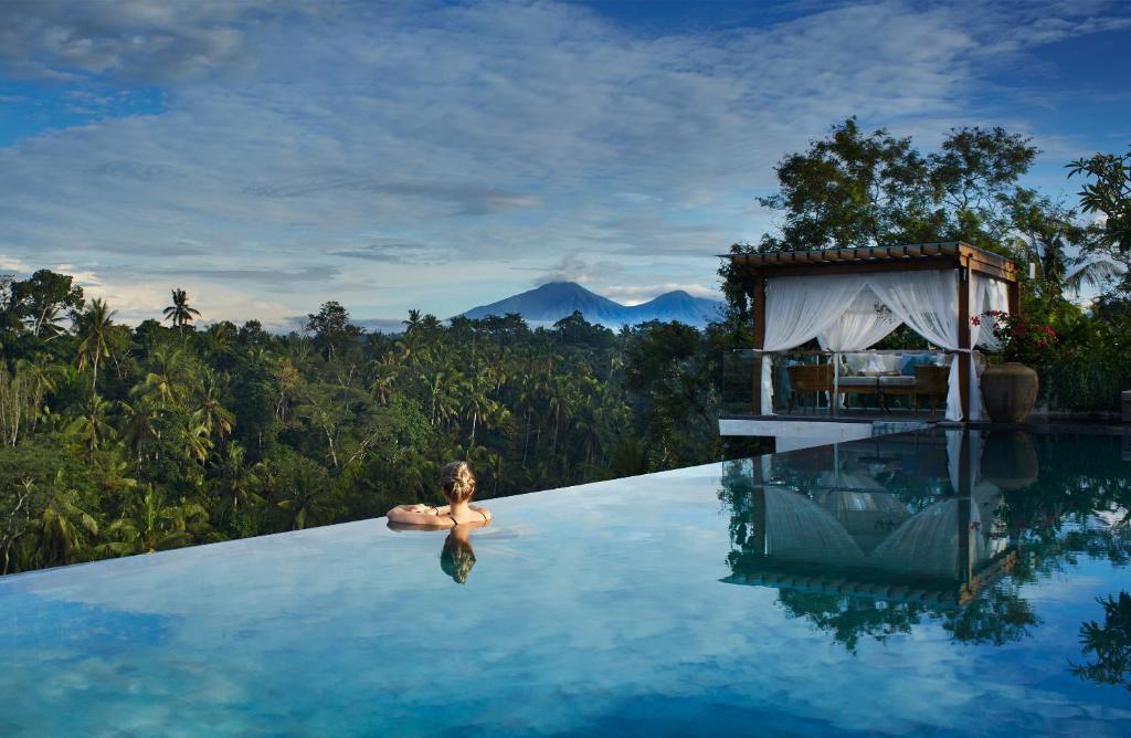 eine Frau im Infinity-Pool eines Resorts in der Unterkunft Goya Boutique Resort in Ubud