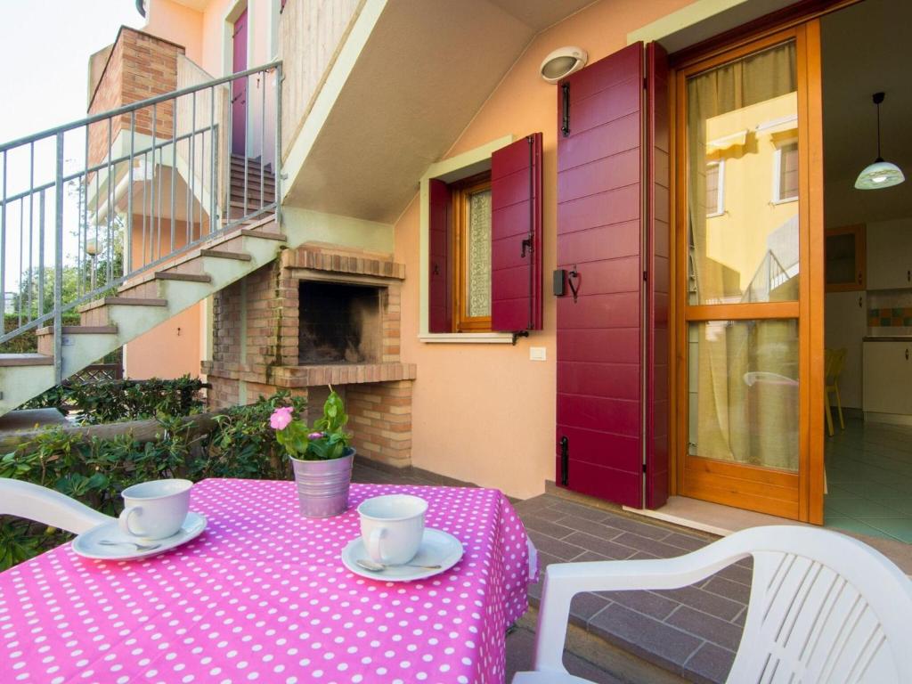 d'une table avec une nappe rose en polka sur une terrasse dans l'établissement Attractive Holiday Home in Rosolina near Lungomare Beach, à Rosolina