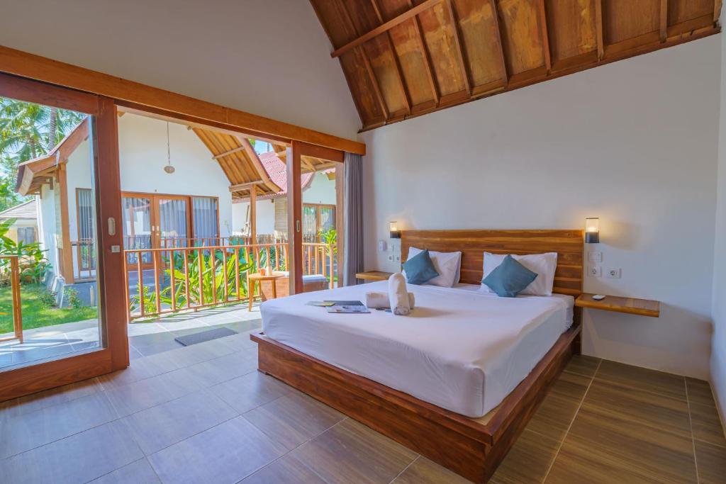 ein Schlafzimmer mit einem Bett und einem großen Fenster in der Unterkunft Twiny's in Kuta Lombok