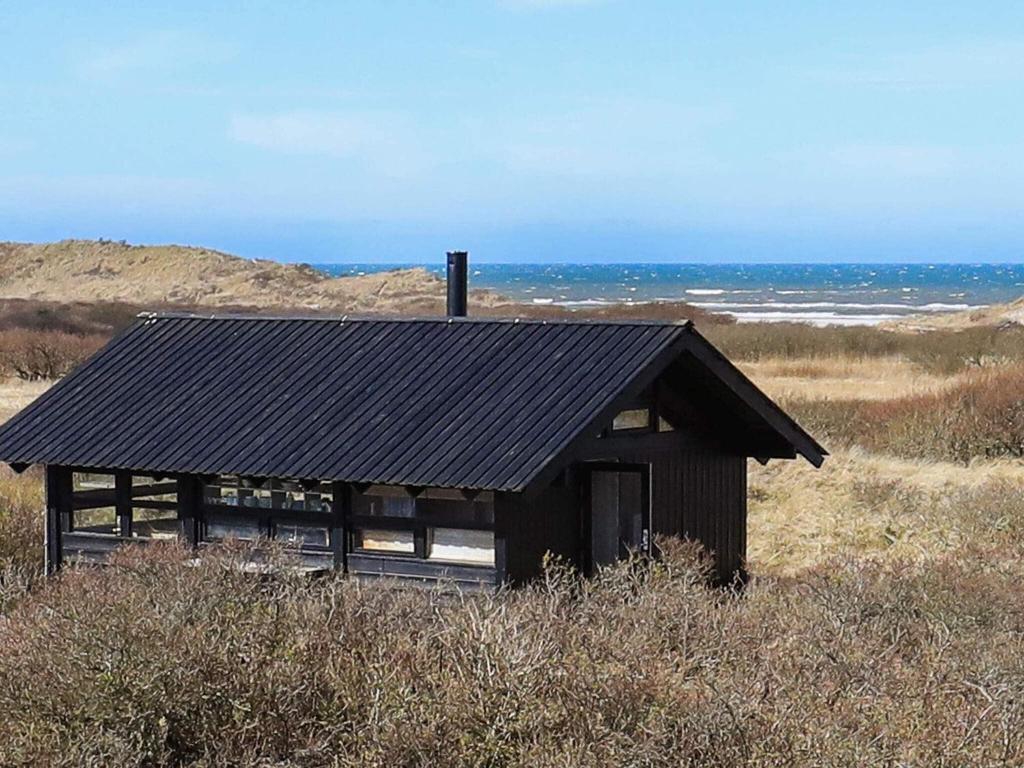 un pequeño edificio en medio de un campo en 4 person holiday home in Bindslev, en Bindslev