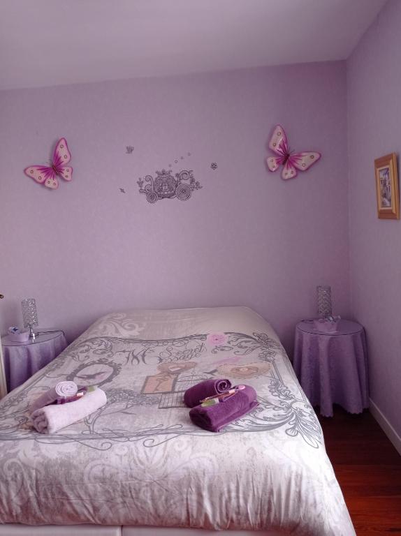 1 dormitorio con 1 cama con mariposas en la pared en Le Relais de la Bulle Enchantée, en Hautvillers