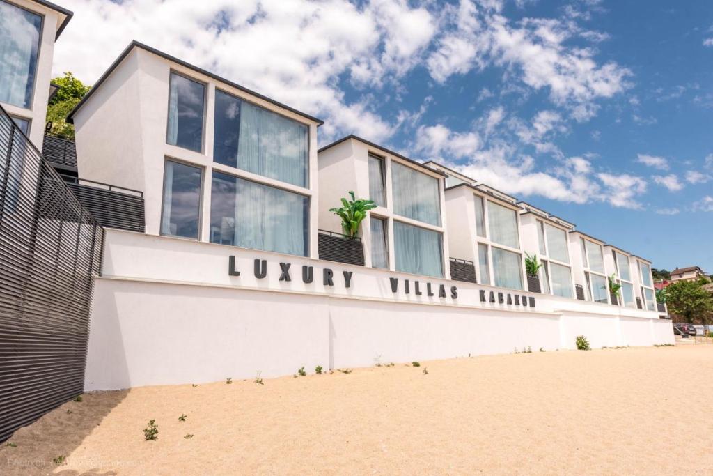 a building on the beach next to the sand at Luxury Villas Kabakum in Golden Sands