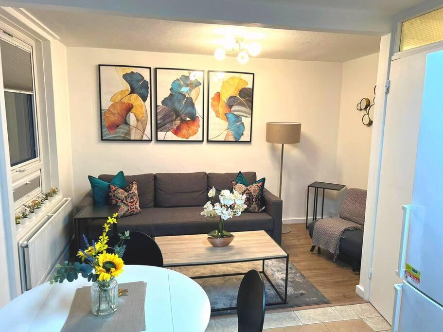 a living room with a couch and a table at FW Haute Apartments at Tottenham Hale, 4 Bedroom and 2 Bathroom Pet-Friendly Duplex Flat, King or Twin beds with FREE WIFI and PARKING in London