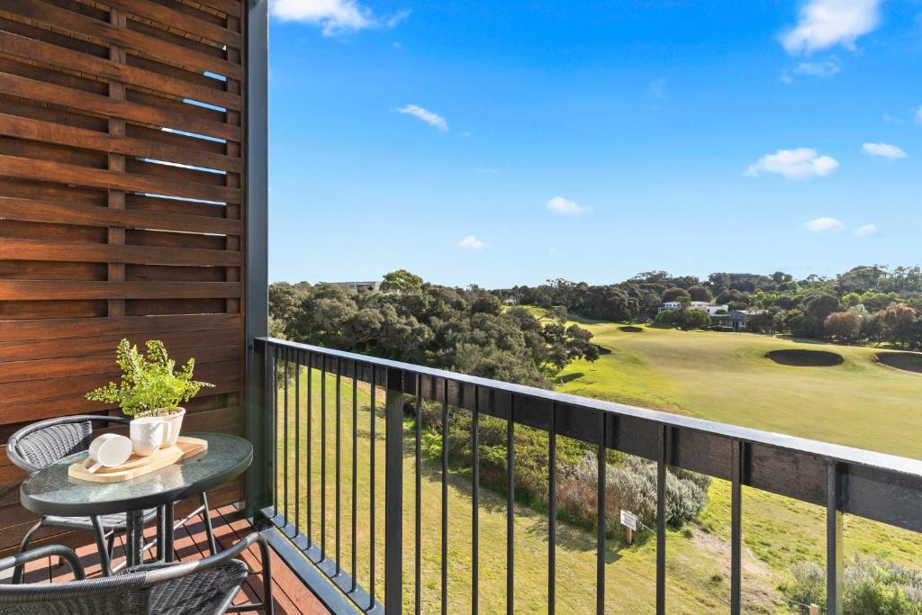 a balcony with a table and a view of a golf course at Fairway Views – Moonah Apartment 23 in Fingal