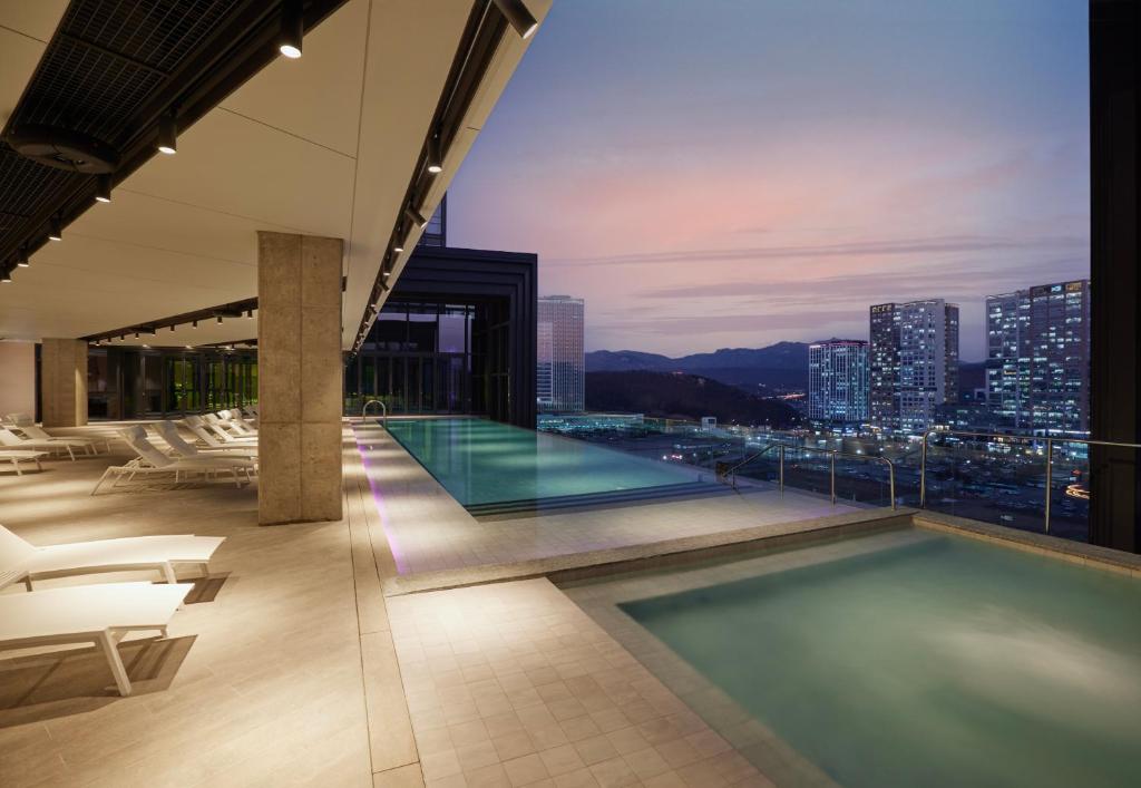 a pool on the top of a building with a city skyline at Take Hotel Seoul Gwangmyeong in Gwangmyeong