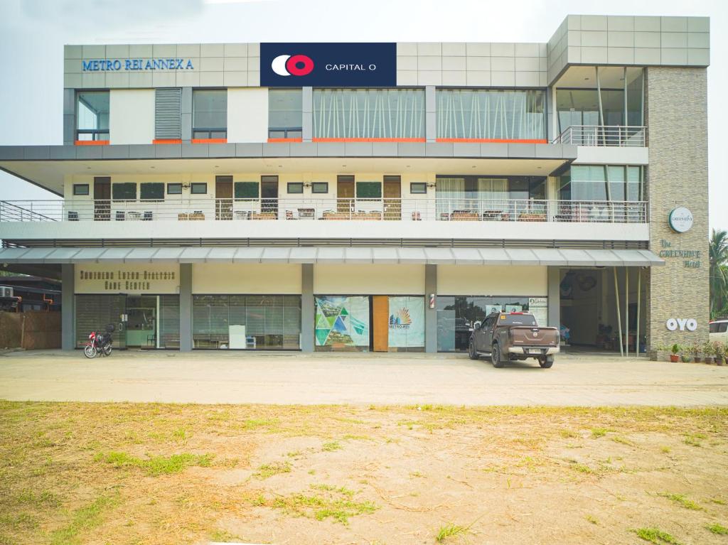 a building with a car parked in front of it at Capital O OYO 785 The Greenhive Hotel in Lapolapo