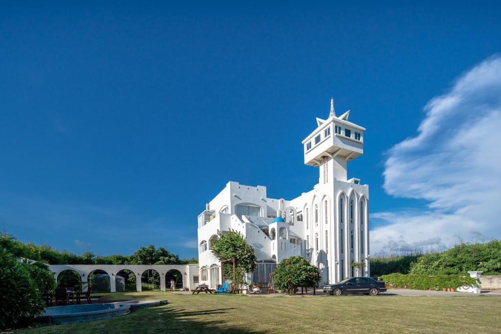 a large white building with a clock tower at 夏日澄藍The Charming Land in Baisha