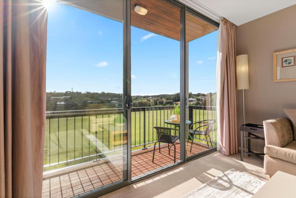 a living room with sliding glass doors leading to a balcony at Fairway Views – Moonah Apartment 24 in Fingal