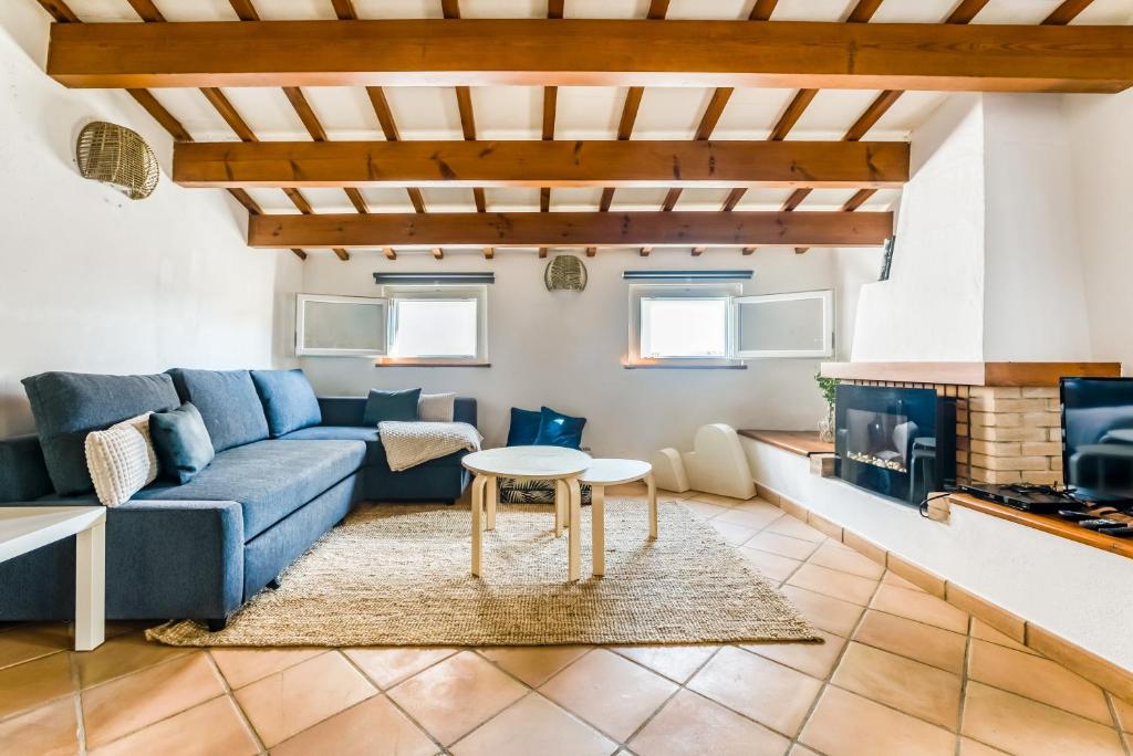 a living room with a blue couch and a table at Casa Agnès in Mahón