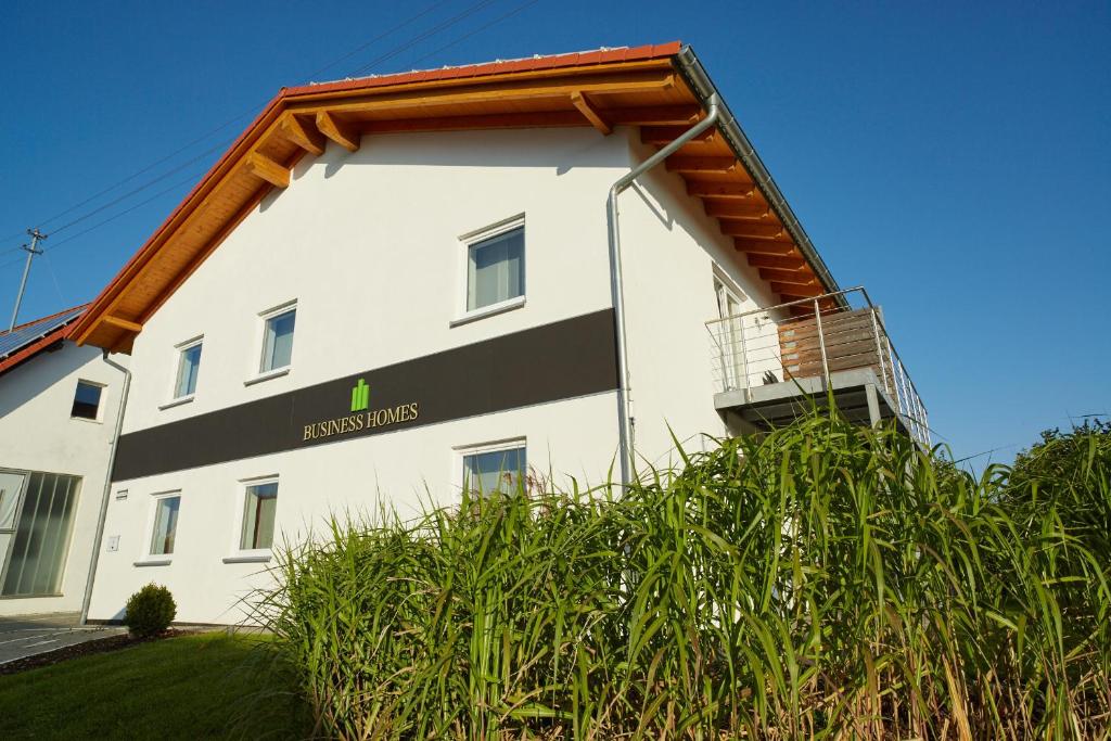 a white building with a sign on the side of it at Business Homes - Das Apartment Hotel in Lauchheim