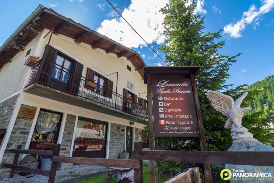 a building with a sign in front of it at Locanda Aquila Bianca in Valprato Soana