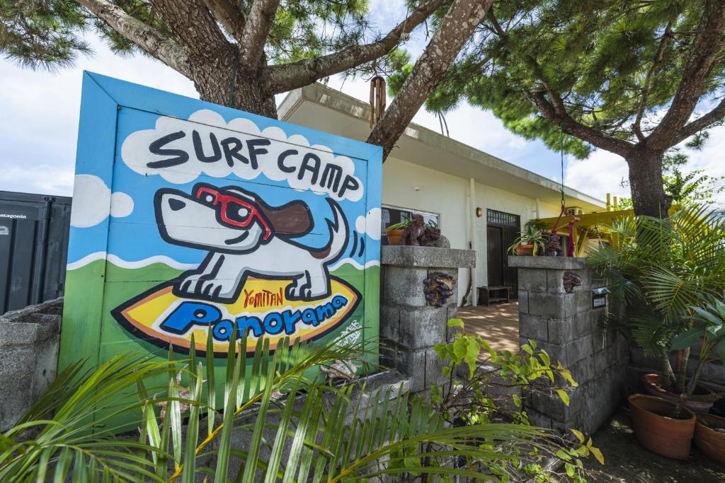 una señal para un campamento de surf frente a una casa en Panorama en Yomitan