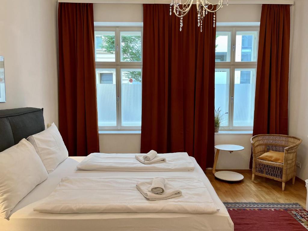 a bedroom with a bed and a window with red curtains at Casa Nostra - Zentrale Wohnung am Augarten in Vienna