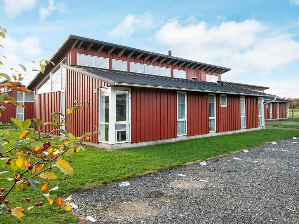 a red building with white windows on the side of it at 6 person holiday home in Bogense in Bogense