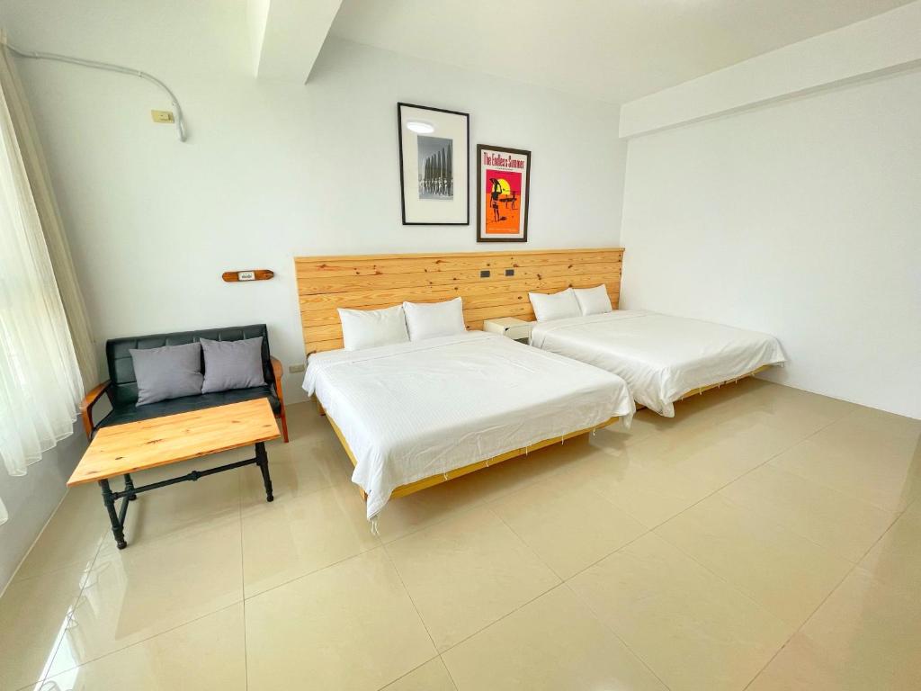 恆春的住宿－墾丁以馬內利衝浪旅店，一间卧室配有两张床,内设长凳