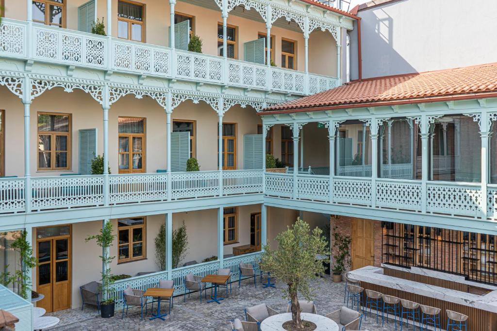 un edificio con un patio con mesas y sillas en The House Hotel Old Tbilisi, en Tiflis